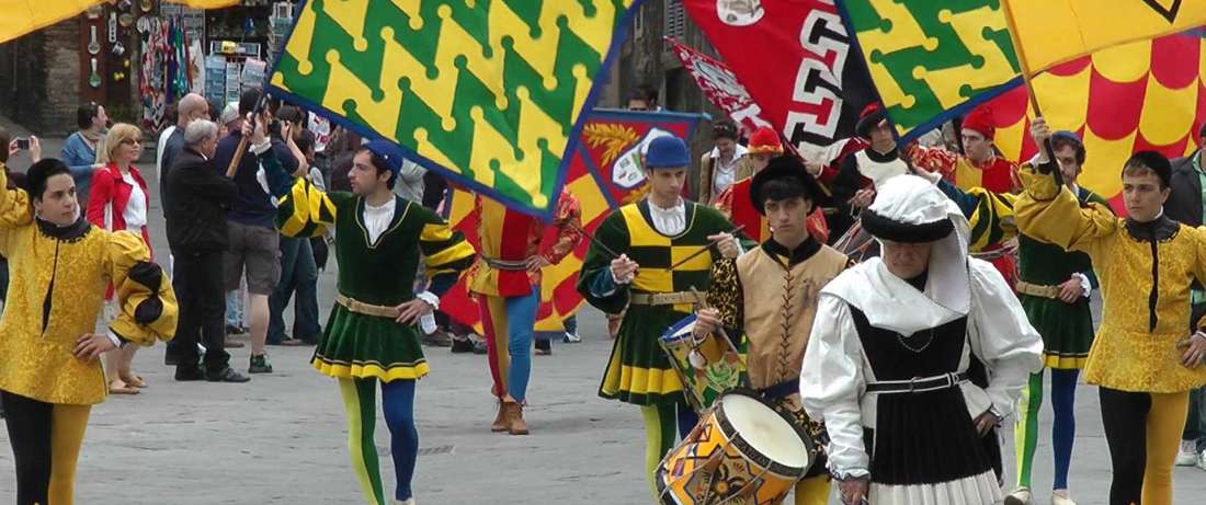 Festzug in historischen Gewändern mit Fahnen und Trommel in Siena